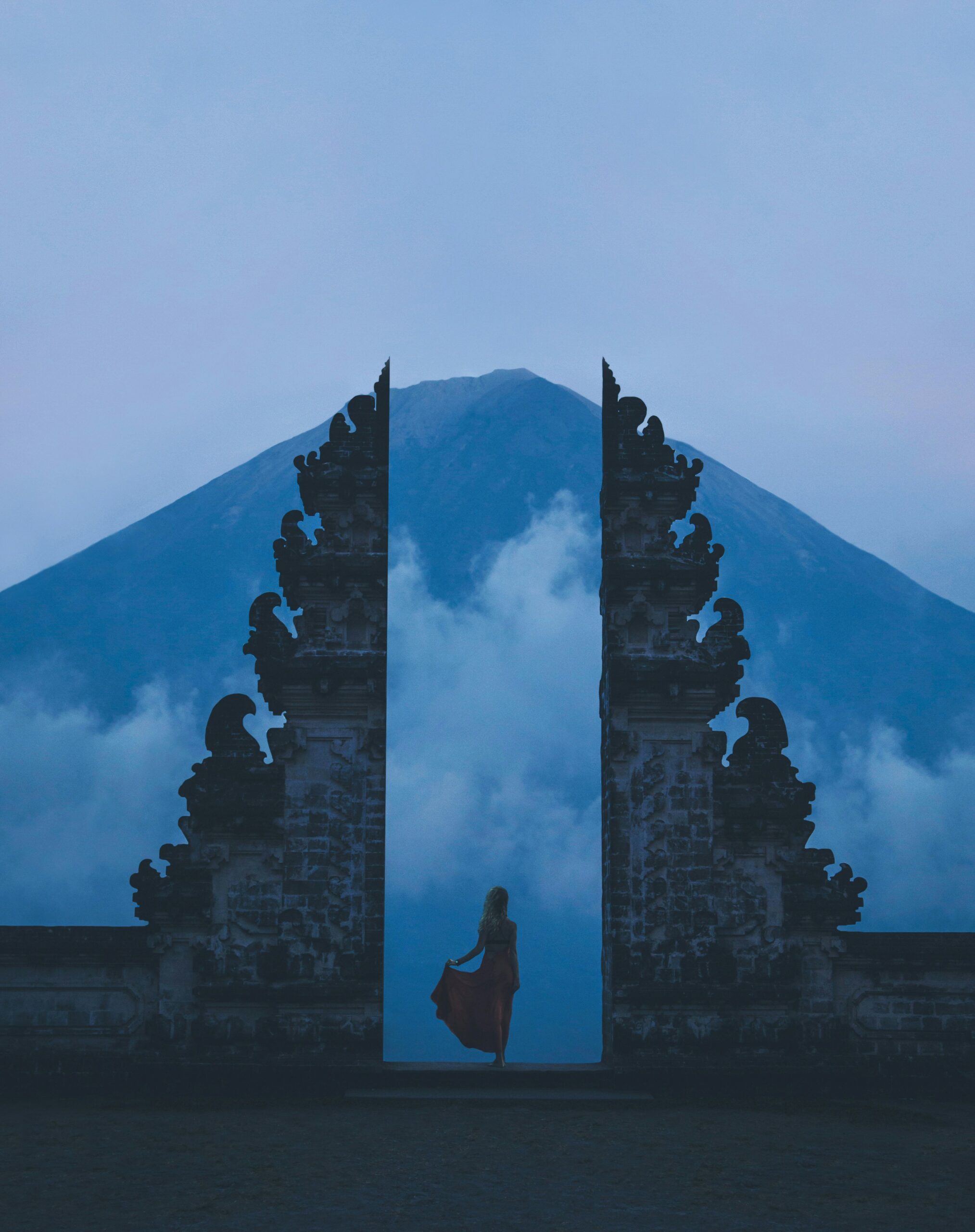 Woman between concrete landmarks and white clouds, freedom, purpose, life mission